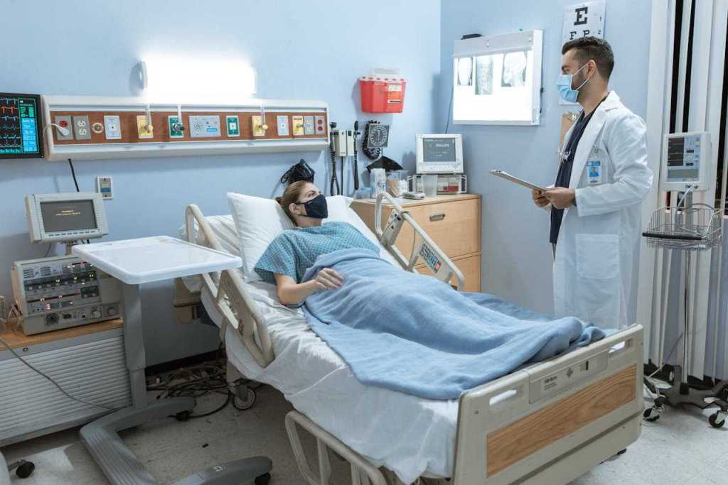 pacient on a hospital bed talking to a doctor